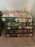 Stack of four Cobble Hill puzzle boxes showing titles and piece counts.