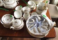 Wide shot of full Minton Brown Elizabethan Oak china set with teapot, bowls, teacups, saucers on wooden table