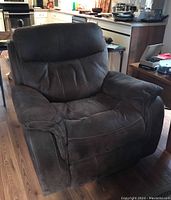 Manual recliner chair front view showing plush cushions and armrests in dark brown fabric with visible stitching.