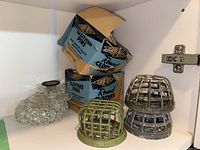 Vintage metal flower frogs in cage design, green net frog, glass pebble holder, and two blue boxes of wooden clothes pins with Grip-Rite branding.