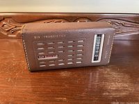 Front and side view of the Koyo Deluxe 6 Transistor AM Portable Radio showing speaker grille, brand logo, and AM tuning dial.