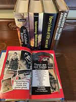 Close-up of the five books stacked horizontally showing the spines and authors, confirming titles and authors, and new condition of covers.