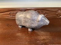 Side profile view of soapstone muskox sculpture showing smooth, rounded body and short legs.