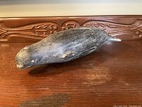 Side view of whale sculpture showing profile and surface patina