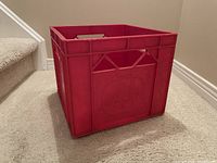 Red milk crate on carpet beside stairs empty