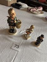 Photo showing all three W. Goebel figurines on table with measuring card '73'