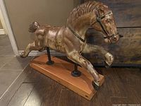 Side view of full horse figure on wooden base
