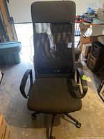 Front view of Ikea MARKUS office chair showing tall mesh backrest and fabric seat.