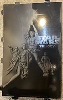 Front panel of the large Star Wars DVD release standee showing main characters and logo in silver foil against black background.