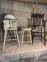 Three pieces: white painted high chair, white painted wooden stool, stained wood high chair
