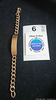 Full length view of bracelet alongside auction card