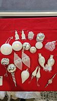 Set of 18 silver and white Christmas ornaments on a red background