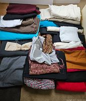 Overall view of large box with many folded fabric pieces in various colors and patterns