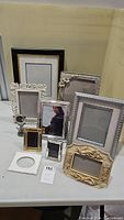 Overview of the collection of ten assorted picture frames with various colors, sizes, and ornamental designs