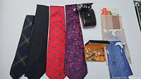 Wide view of ties, handkerchiefs, and Lupinus binoculars in case