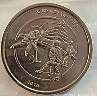 Close-up of a single Canadian Tire hockey coin showing detailed engraving of hockey players and year 2010