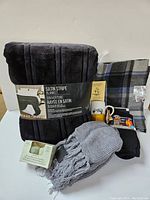 Full lot view showing blanket, scarves, socks, mug, and aromatherapy candles