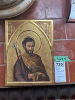 Full view of rectangular wood panel with painting of bearded saint in gold leaf background