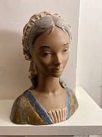 Front view of bust showing facial features, dress detail and glaze finish.