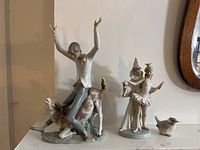 Overview shot of all three porcelain Lladro figurines displayed on shelf
