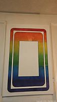 Full front view of original abstract rainbow gradient painting on stretched canvas hung on wall.