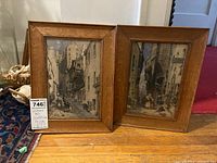 Two framed prints from Wilsons Art Galleries with wooden frames, showing detailed street scenes with groups of people.