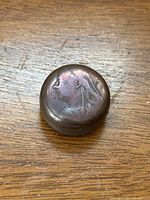 Top view of Victorian penny box lid embossed with a profile of a Victorian woman.
