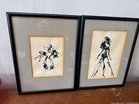 Two framed abstract ink artworks side by side showing whole pieces and frames.