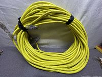 Full coiled 100-foot bright yellow heavy duty extension cord.