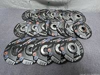 19 WALTER ZipWheel cutting discs displayed in a group showing the top side with labeling and information.