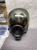 Front view of full black Advantage 1000 full-facepiece respirator showing tinted flexible lens and filter attachment point.