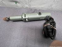 Full side view of Makita die grinder with attached grinding stone and power cord.