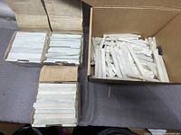 Top-down view of several cardboard boxes filled with white soft mineral marking strips.