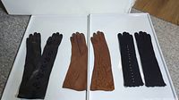 Three pairs of vintage long sleeve gloves displayed side by side: two leather pairs in brown and black, and one pair of black knit gloves.