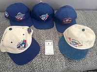 Front and back view of all five hats together showing variety of Blue Jays 1992 World Series logos and embroidery