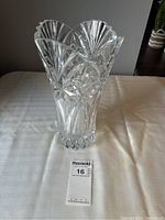 Front view of clear crystal vase with detailed cut patterns, scalloped top edge, and thick base. Small chip not visible in this photo.
