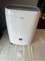 Front view of white TCL dehumidifier showing the logo and overall device body.
