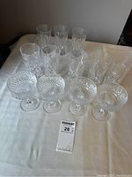 Photo showing all 12 glasses including four diamond-cut crystal low glasses, five vertically-cut crystal highball glasses, and three clear plain highball glasses