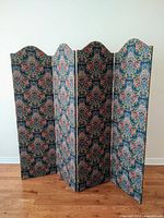 Full view of four-panel folding vintage fabric screen, showing floral damask fabric pattern and scalloped tops.