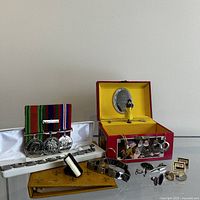 Full view of jewelry box with Snow White and Seven Dwarfs illustration, open to show figurine and mirror, displayed with vintage cufflinks, tie bar, watch, magnet bracelets, and photo album.