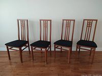 Four high-back wood dining chairs in a row front view