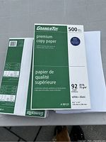 Photo of closed and open packages of Grand & Toy premium copy paper, showing packaging details and sheet size 8.5 x 14 inches.