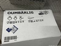 Closed box showing OUMBÄRLIG brand and packaging details, including pot sizes and icons showing stovetop and oven compatibility.
