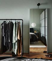 Full view of tall rectangular IKEA Hovet floor mirror standing in a room, reflecting interior details.