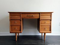 Front elevation of desk showing overall form, pedestal drawers and tapered legs