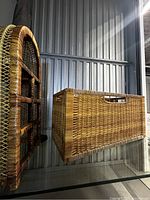 Photo showing the rectangular wicker blanket storage box with its removable bottom panel displayed beside it.