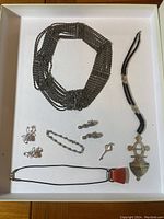 Full view of various Judith Ripka sterling silver jewelry pieces laid flat in a white box including necklaces, earrings, and pendants.