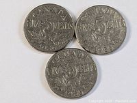 Three 1930s Canadian five cent coins showing fronts with date and maple leaf design.