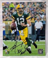 Photo showing full 8x10 signed image of Aaron Rodgers on field in action in Green Bay Packers uniform, autograph visible