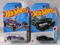 Photo of two new Hot Wheels cars in original packaging, showing front of packaging and cars inside